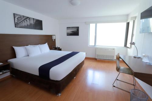 a hotel room with a bed and a desk and a bed at Casa Andina Select Miraflores in Lima