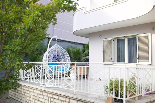a white swing on a balcony of a house at Rooms by Romi in Durrës