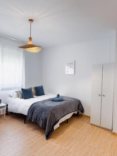 a white bedroom with a bed with blue pillows at Sea Estudio Cala de Mijas in La Cala de Mijas