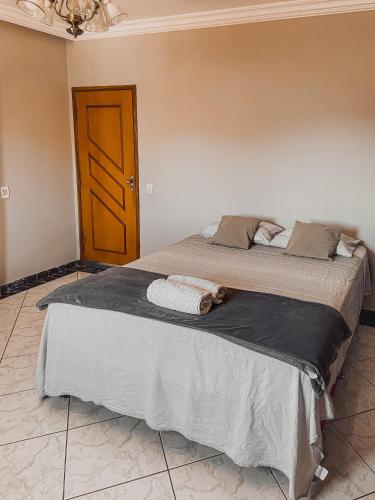 a large bed in a room with a brown door at Hostel Network - Faça Novas Conexões, Desfrute de Qualidade e Privacidade in Anápolis
