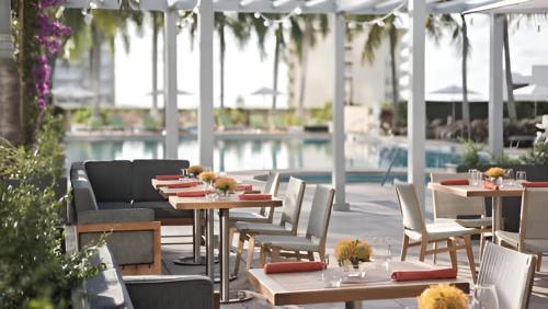 a patio with tables and chairs and a pool at Live the Miami Experience in an Exclusive Condo 4S in Miami