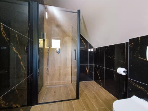 W łazience znajduje się prysznic ze szklanymi drzwiami. w obiekcie Apartments Poljanak Green House w mieście Jeziora Plitwickie