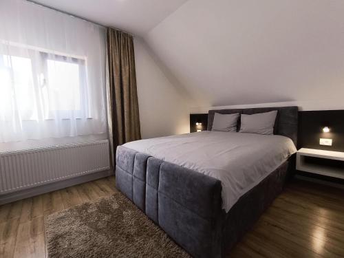 sypialnia z dużym łóżkiem i oknem w obiekcie Apartments Poljanak Green House w mieście Jeziora Plitwickie