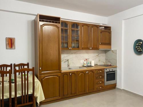 - une cuisine avec des placards en bois et un évier dans l'établissement Albanian Riviera Appartement, à Vlorë