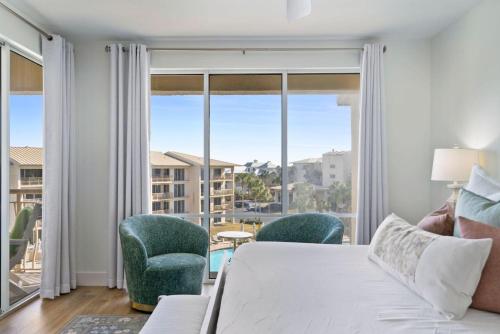 salon z łóżkiem i krzesłami oraz dużym oknem w obiekcie High Pointe Resort 432 w mieście Inlet Beach