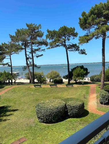 a park with benches and trees and the ocean at Vue mer in Arcachon