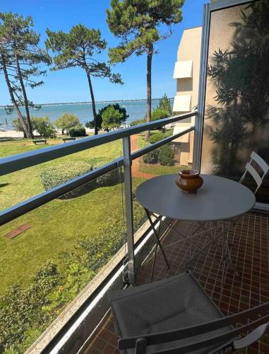 un tavolo e una sedia su un balcone con vista sull'oceano di Vue mer ad Arcachon