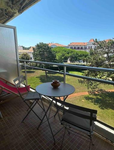 un patio con tavolo e sedie sul balcone. di Vue mer ad Arcachon