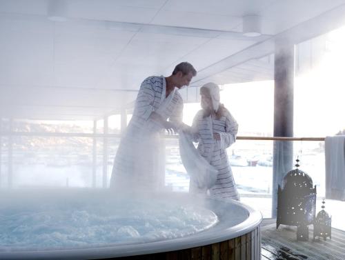 a couple of people standing in a hot tub at Strömstad Spa & Resort in Strömstad
