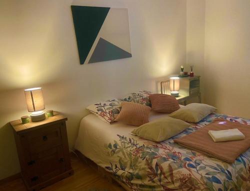 a bedroom with a bed with two lamps on it at Maison indépendante in Noyant-dʼAllier