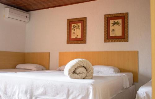 um quarto com duas camas com uma toalha na cama em Goldmen Hotel Fazenda em Guarapuava