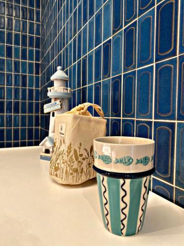 a couple of cups sitting on a counter in a bathroom at La Canadienne in Courseulles-sur-Mer