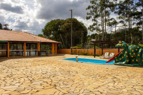 um parque infantil com escorrega e uma estátua de cavalo em Goldmen Hotel Fazenda em Guarapuava