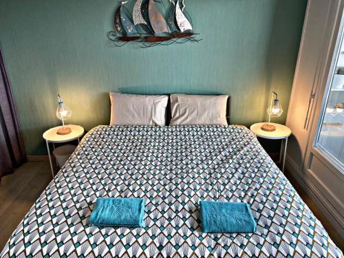 a bedroom with a bed with two lamps on two tables at La Canadienne in Courseulles-sur-Mer