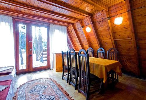Rząsawa的住宿－Warzkowizna，小屋内带桌椅的用餐室