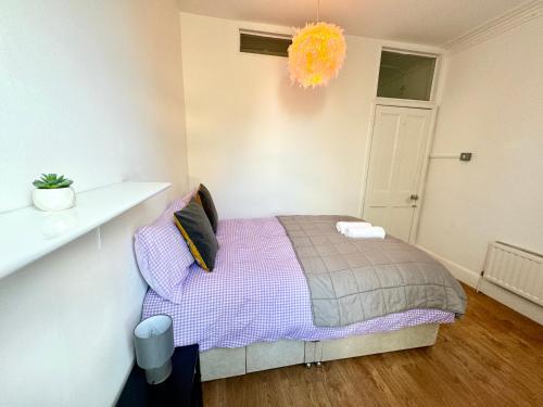 a bedroom with a bed and a chandelier at Adorable room near City Centre in Bristol