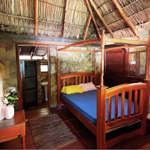 Las Chelitas Casa del Mar - Nueva Administración de Maru Mar في بوبويو: غرفة نوم بسرير خشبي في غرفة