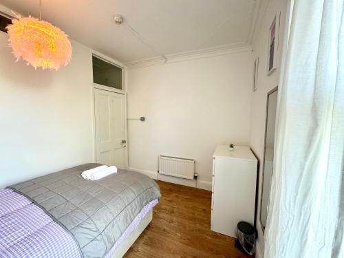 a small bedroom with a bed and a refrigerator at Adorable room near City Centre in Bristol