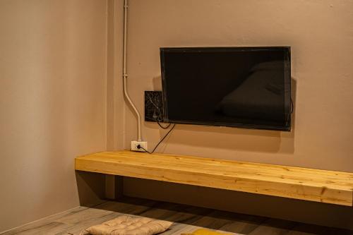 einen Flachbild-TV, der an einer Wand hängt in der Unterkunft Miki House in Chumphon