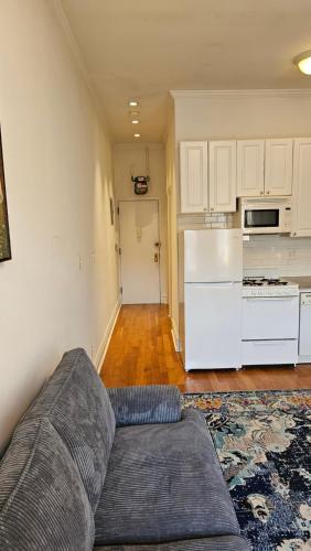 a living room with a couch and a kitchen at Incentra Village Hotel in New York