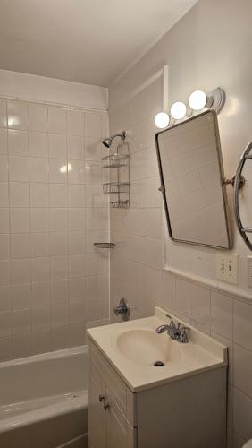 y baño con lavabo, espejo y bañera. en Incentra Village Hotel en Nueva York