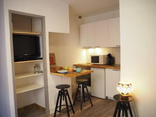 - une petite cuisine avec un comptoir et des tabourets dans l'établissement 1km des plages Parking gratuit, à Sainte-Croix-de-Verdon