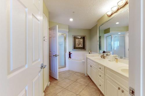 a bathroom with a sink and a tub and a toilet at The Crescent 104 in Destin