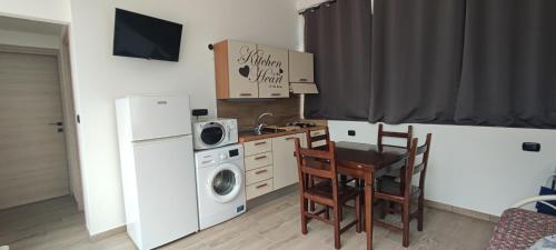 una piccola cucina con tavolo e lavatrice/asciugatrice di Le Camine SPA, clima, parking, giardino a Matino