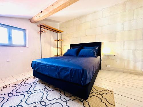 - une chambre avec un grand lit bleu dans l'établissement Appartement en hyper centre d'Arles, à Arles