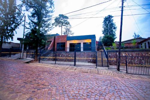 een hek voor een gebouw met een huis bij Guest Suite in Kigali in Kigali