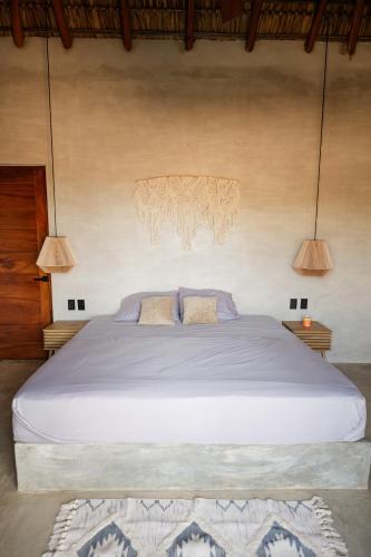 a bedroom with a large bed with two pillows at Casa Mochila in Malucano