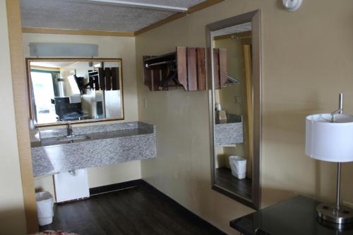 ein Bad mit einem Waschbecken und einem Spiegel in der Unterkunft Executive Inn & Suites in Nashville