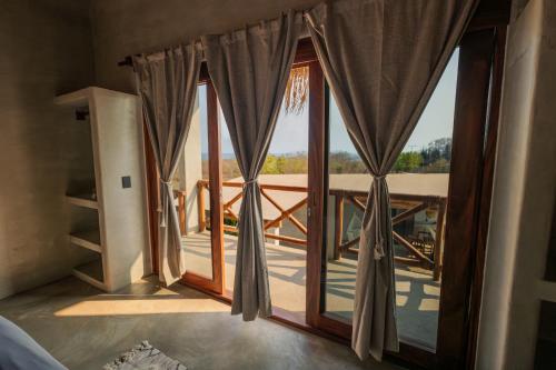 a room with a window with a view of a balcony at Casa Mochila in Malucano