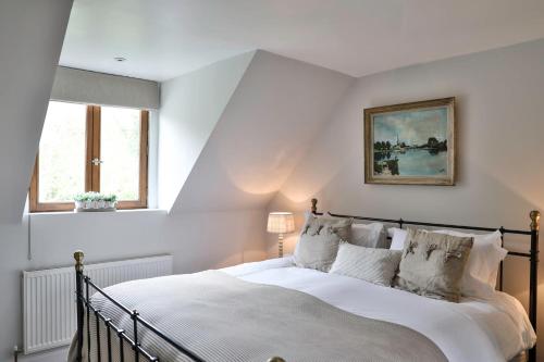ein Schlafzimmer mit einem großen Bett mit weißen Laken und Kissen in der Unterkunft Cotswold Luxury Coach House - ideal for couples, w/ EV charging in Andoversford