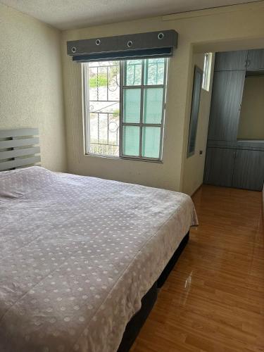ein Schlafzimmer mit einem großen Bett und einem Fenster in der Unterkunft Casa Vazquez Colinas Plata in Cadena