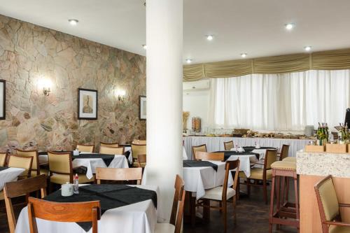 Hotel Sinuelo في جاغواراو: غرفة طعام بها طاولات وكراسي وغرفة بها