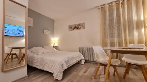 une chambre avec un lit, une table et des chaises dans l'établissement Superbes studios du Parc Paradis, à Gréoux-les-Bains