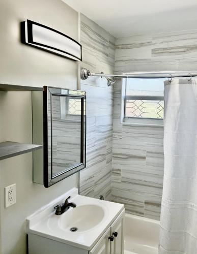 a white bathroom with a sink and a mirror at Perfect remote work spot! Close to everything! in West Palm Beach