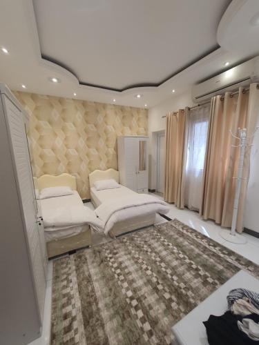a bedroom with two beds and a rug at الخوير هوم in Muscat