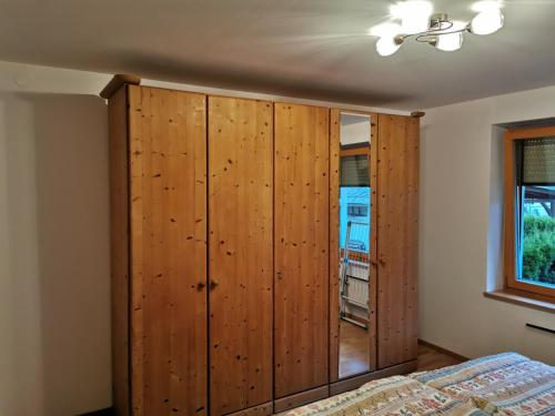 een slaapkamer met een houten kast en een bed bij Apartma Lana in Mojstrana