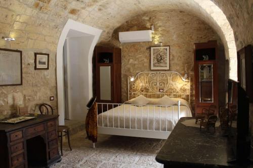 a bedroom with a bed in a stone wall at Casale Arezzo - Luxury Villa With Pool & Jacuzzi - Marina di Ragusa in Ragusa