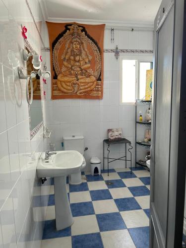 a bathroom with a sink and a painting on the wall at Habitacion Barbacana 3 Carmona in Carmona