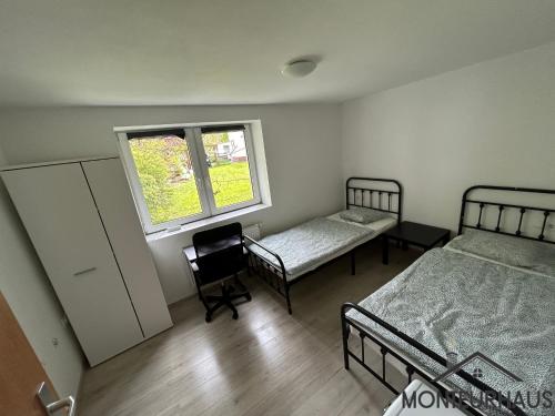 1 Schlafzimmer mit 2 Betten und einem Fenster in der Unterkunft Monteurhaus in Unterkirchberg