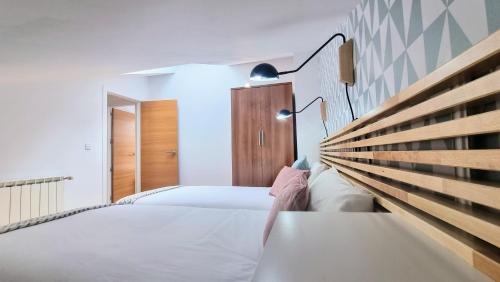 a bedroom with two beds and a wooden headboard at El Rincon de las Americas in Colombres