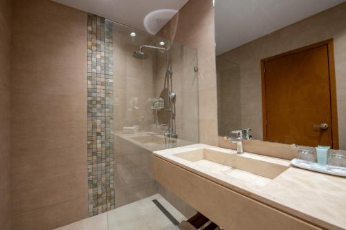 ein Bad mit einem Waschbecken und einer Dusche in der Unterkunft Hacienda Samana Bay Hotel in Santa Bárbara de Samaná