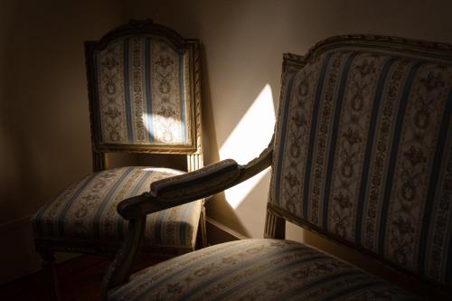 two chairs sitting next to each other in a room at Château de Melin - B&B in Auxey-Duresses