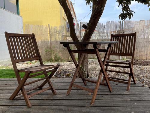 a table and two chairs sitting next to a tree at Casa do Cristo Rei I in Almada
