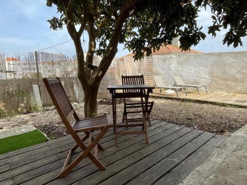 two chairs and a table on a wooden deck at Casa do Cristo Rei I in Almada