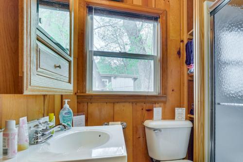 ein Bad mit einem WC, einem Waschbecken und einem Fenster in der Unterkunft Cozy Wisconsin Cabin Walk to Beach and Boat Ramp! in McGregor