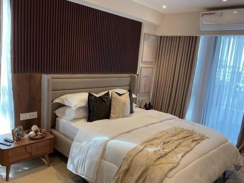 una camera da letto con un grande letto bianco con cuscini di 1-Bed Corner Apartment with Ocean & City Views a Accra